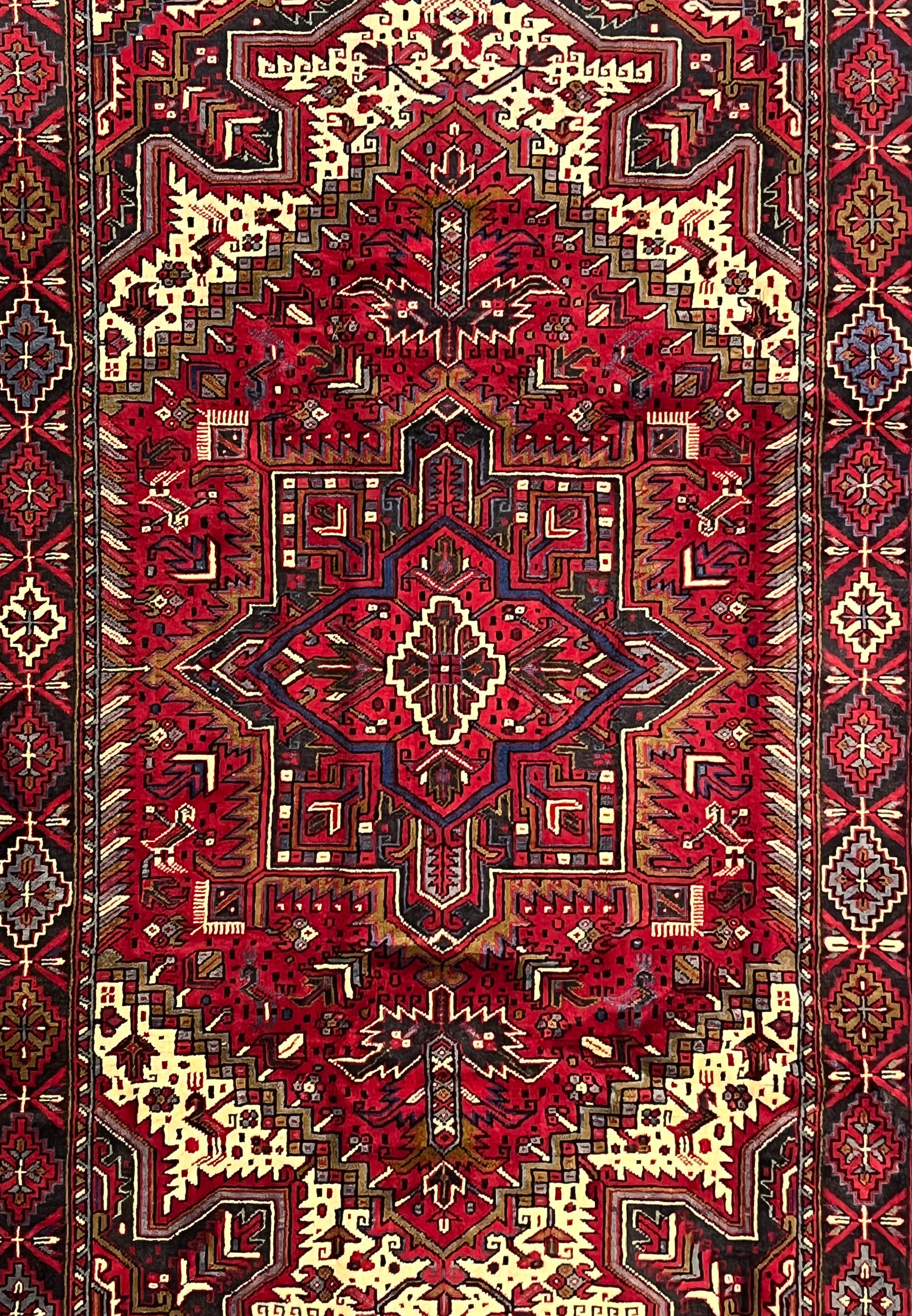 Midfield detail of Persian Heriz rug highlighting sharp geometric lines stacked motifs and dense knotting in classic tribal layout