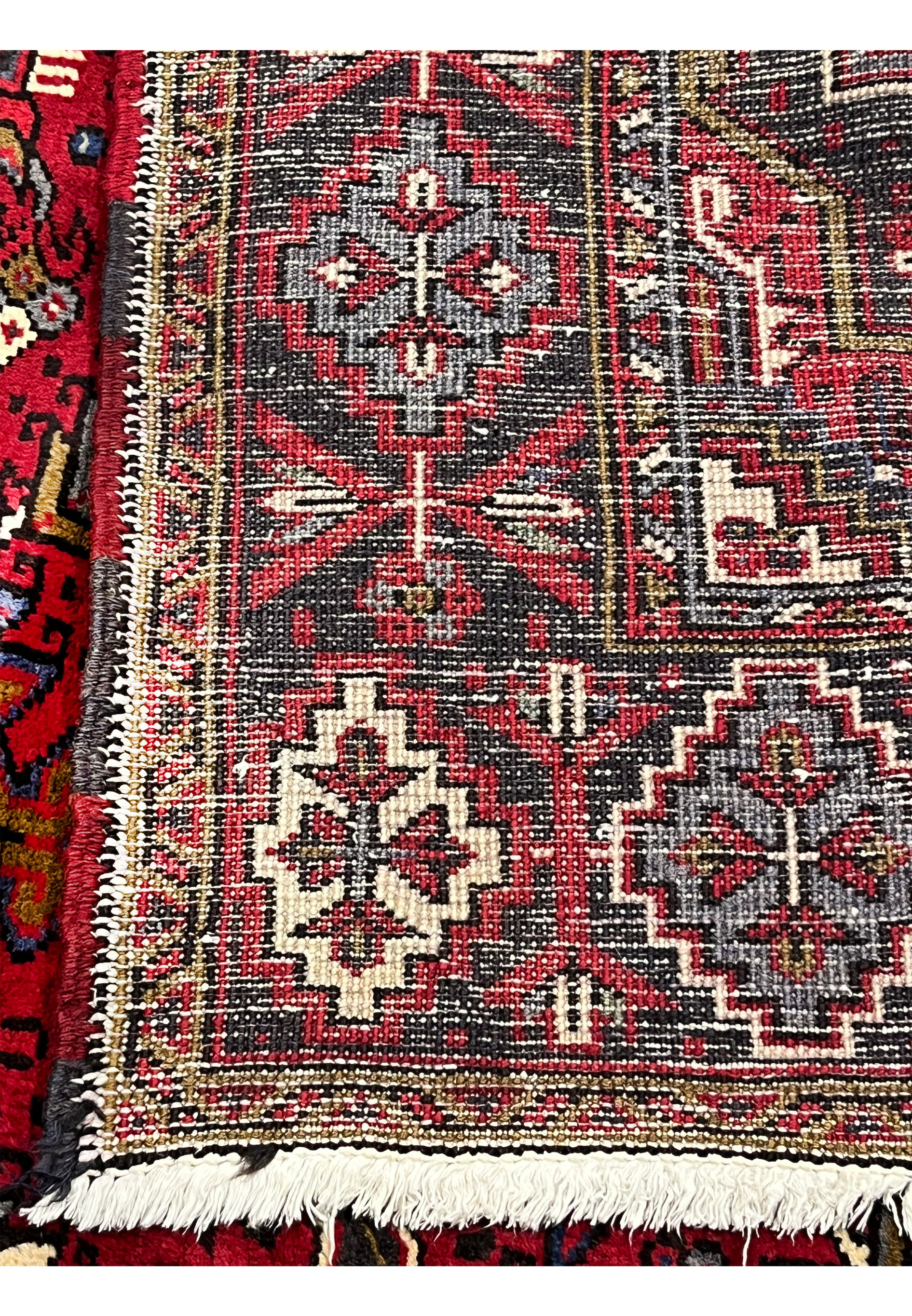 Backside of handmade Heriz rug showing tight knot density, natural wool foundation and clear tribal pattern visible through the weave structure