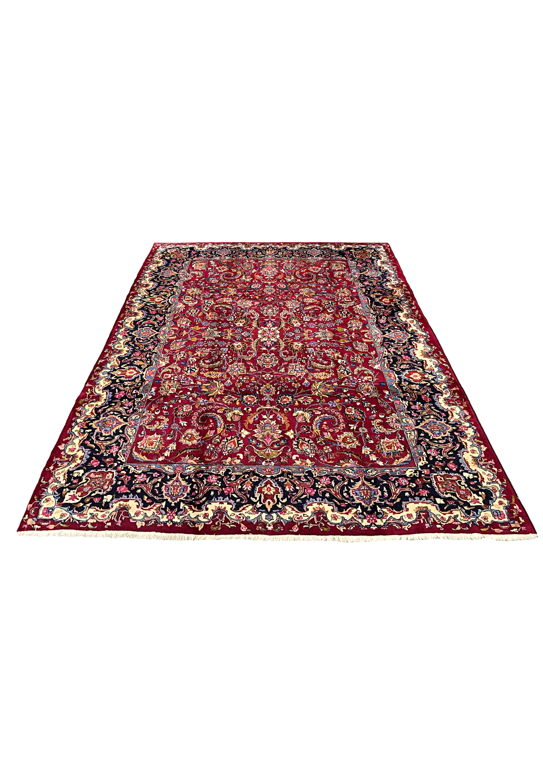 Laid down view of handmade Persian Mashad rug showing full proportions, rich red field, and elegant navy border framing