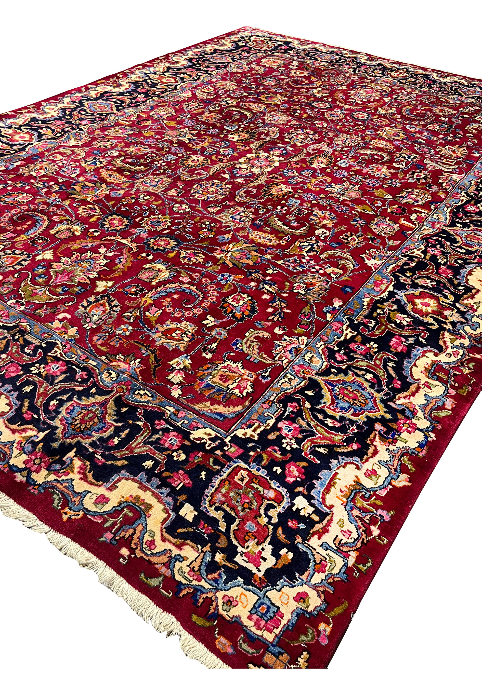 Angled perspective of Persian Mashad rug revealing pile height, color saturation, and dimensional floral patterning