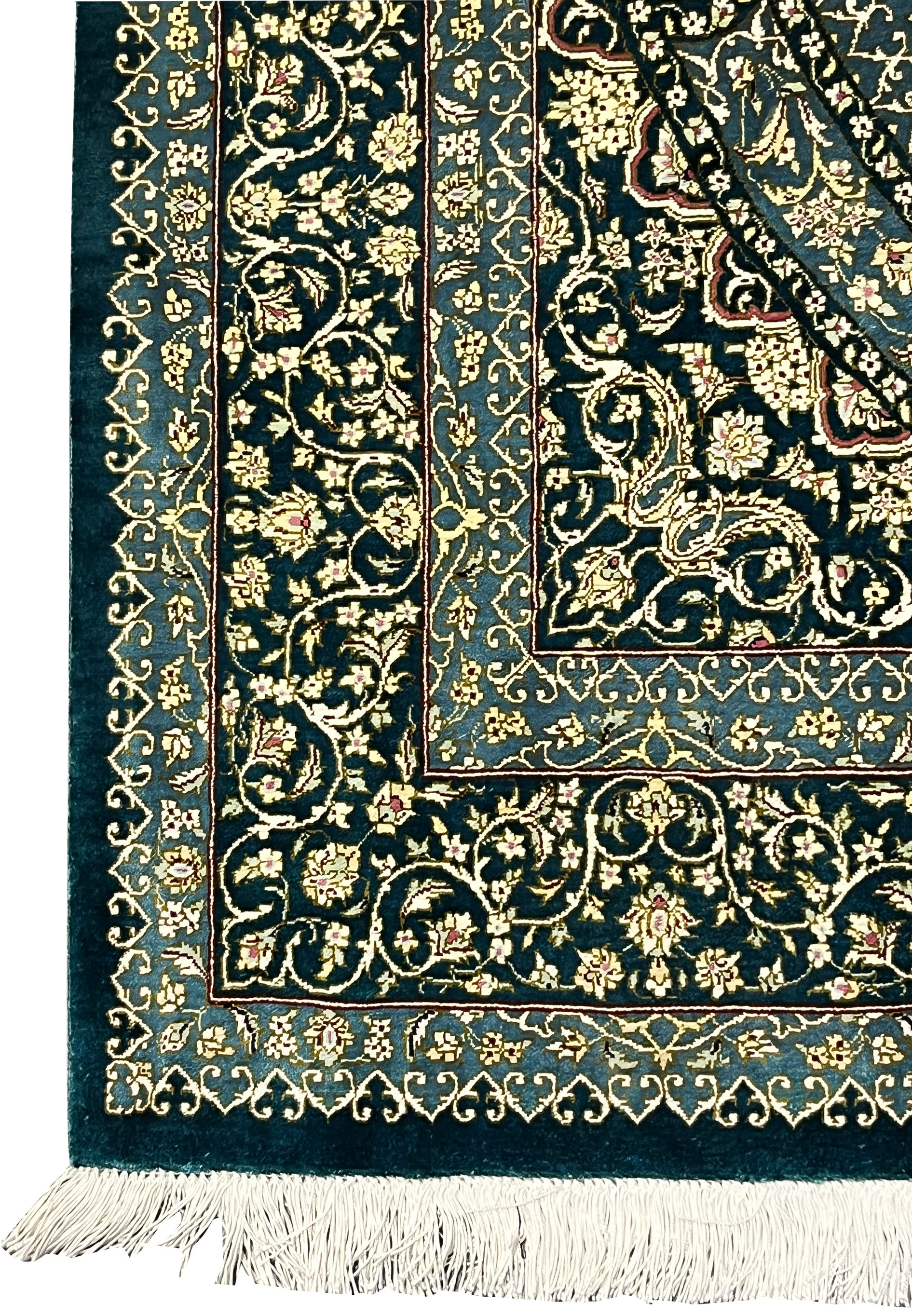 Side border detail of silk Persian Qum rug with layered guard bands, scrolling vines, navy outlines and cream florals in luminous silk weave