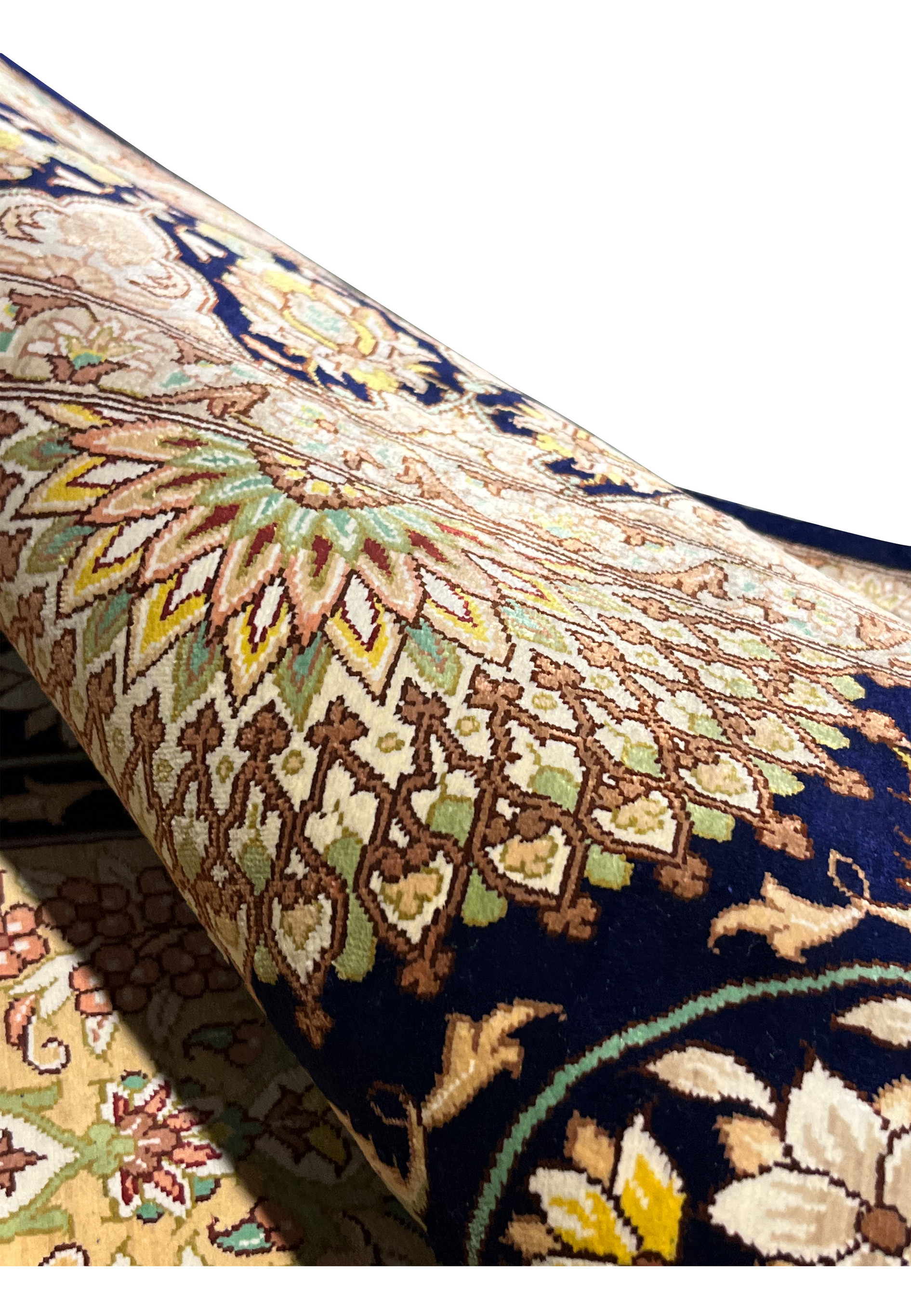 Rolled silk rug view highlighting flexible drape, luminous sheen and ultra fine knot structure typical of premium Qum workshop craftsmanship.