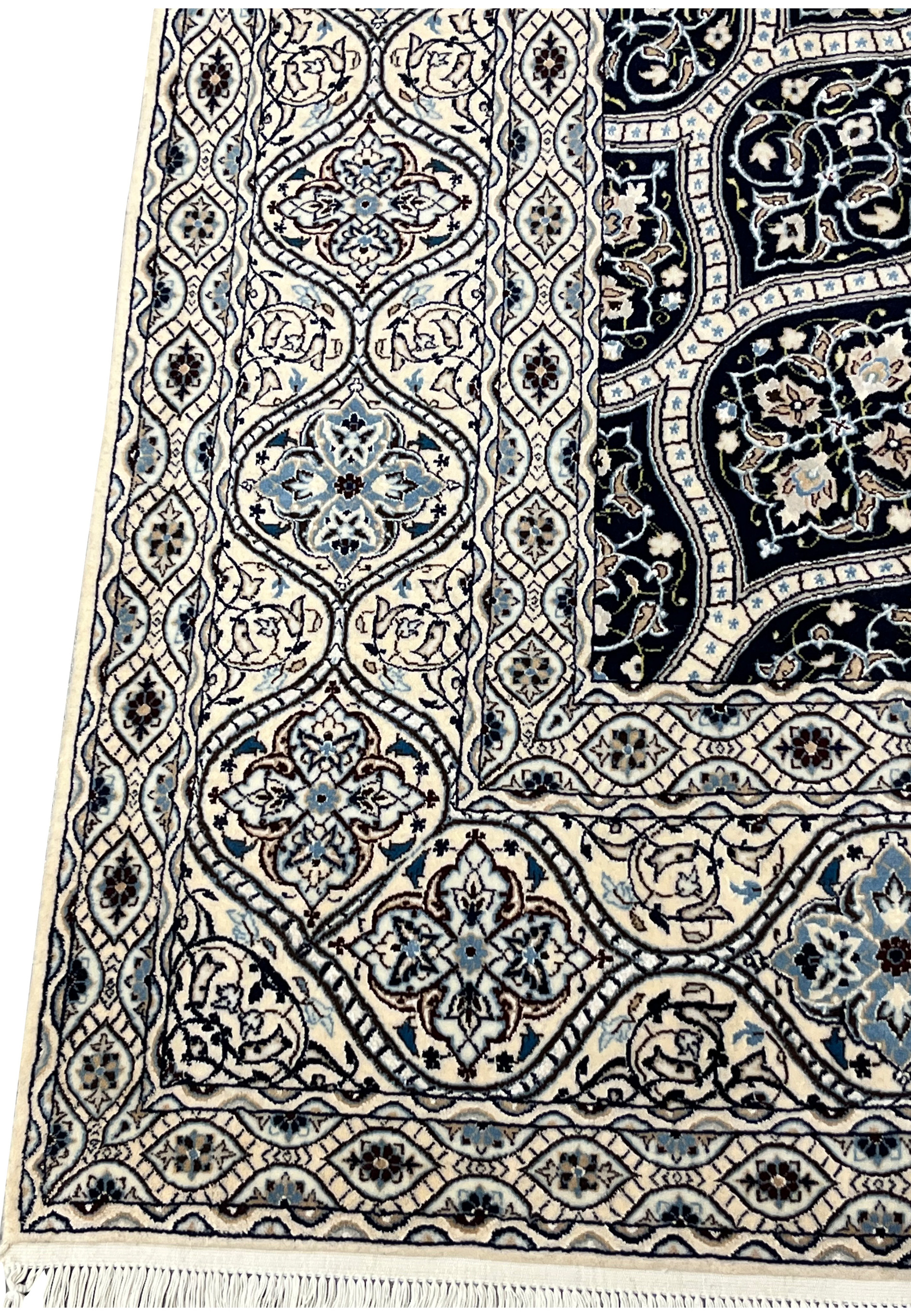 Side view showing low dense pile of Persian Nain 6 LA Kork wool rug with silk floral highlights navy dome pattern.
