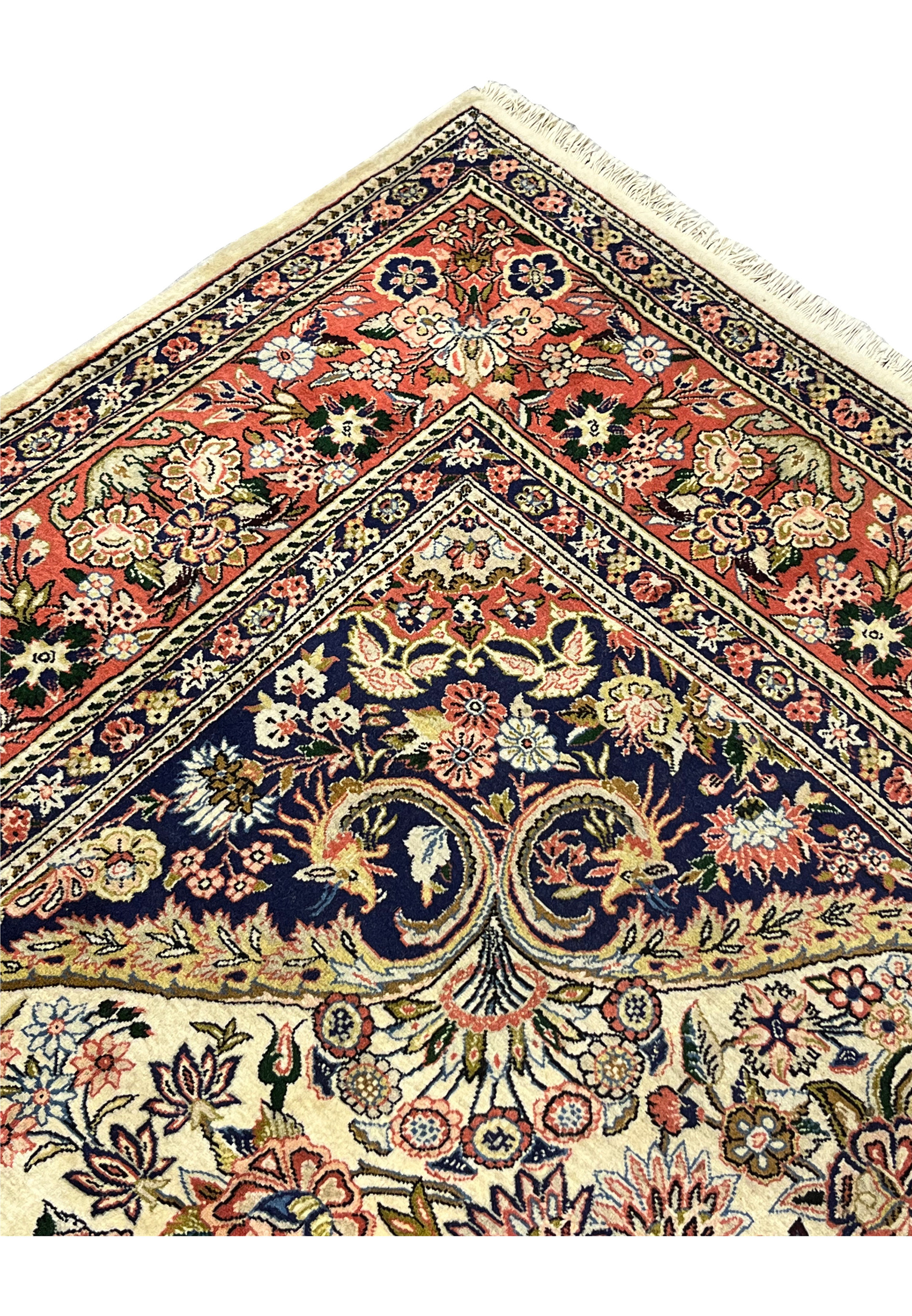 Folded edge of Persian Bijar rug displaying coral border navy guard bands and tightly woven pile structure