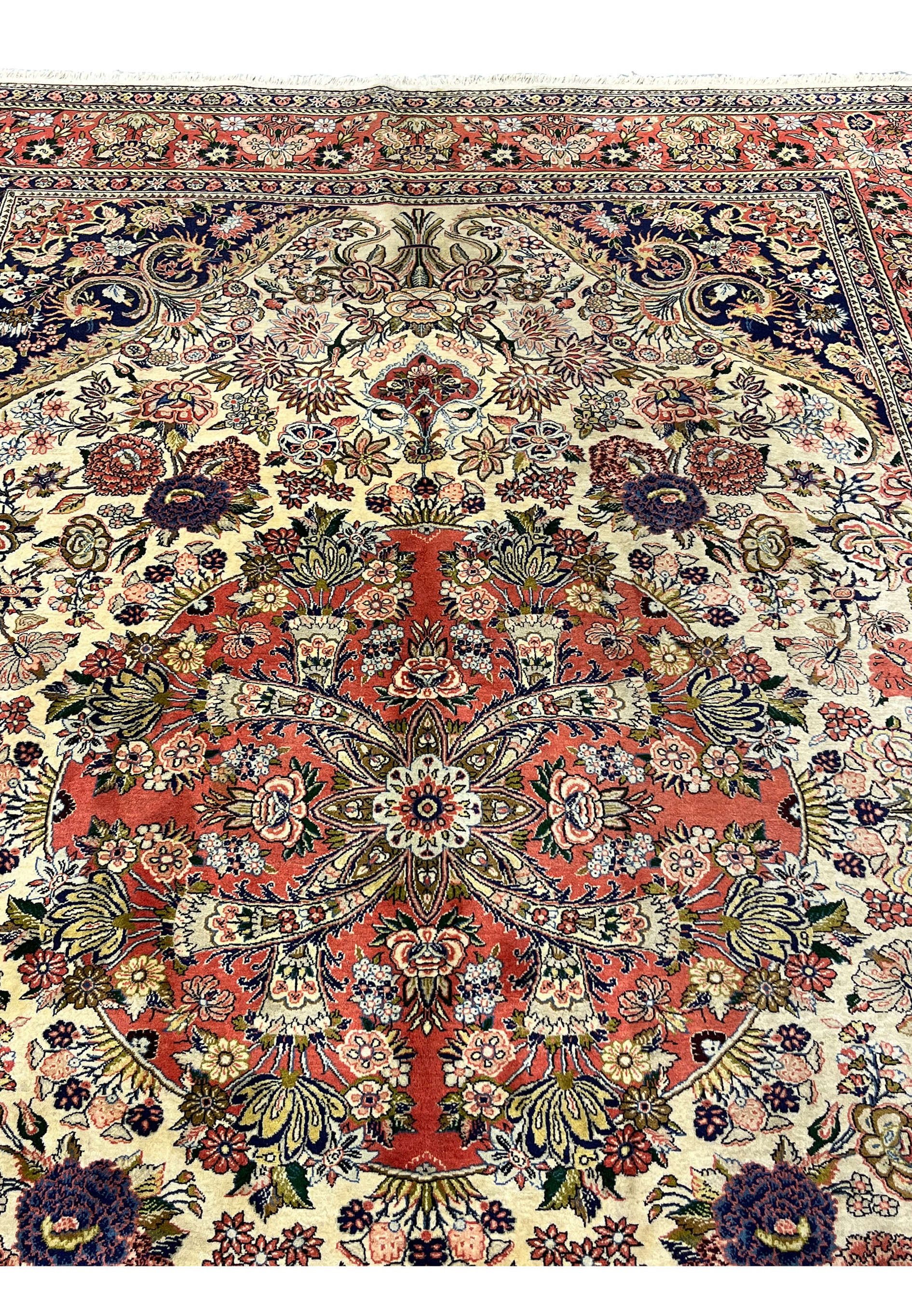 Upper section of Persian Bijar rug featuring navy corner spandrels ivory field and elaborate floral bouquets