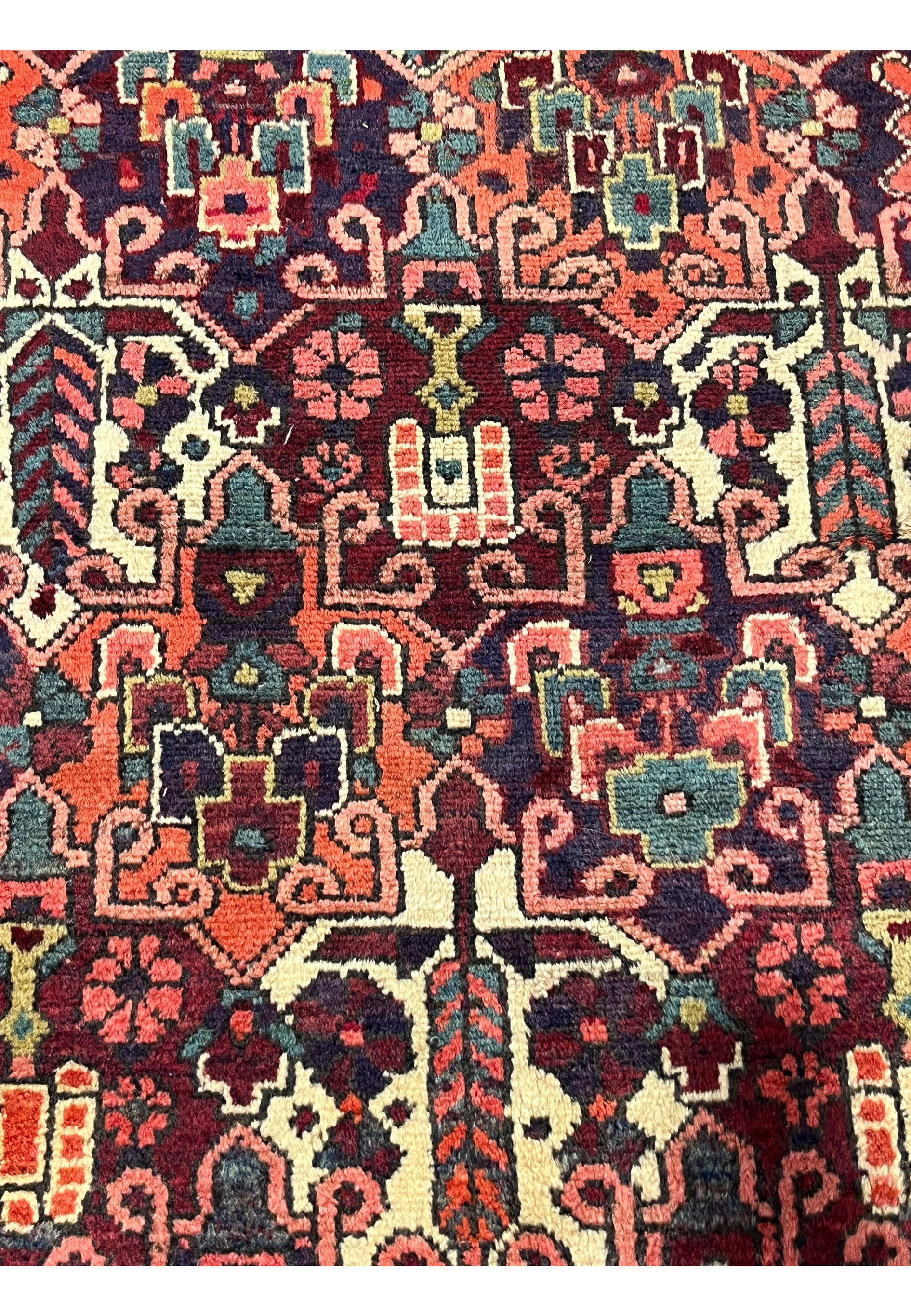 Close-up of floral motifs in antique 3'7x5 Persian Bakhtiari wool rug, navy orange teal ivory