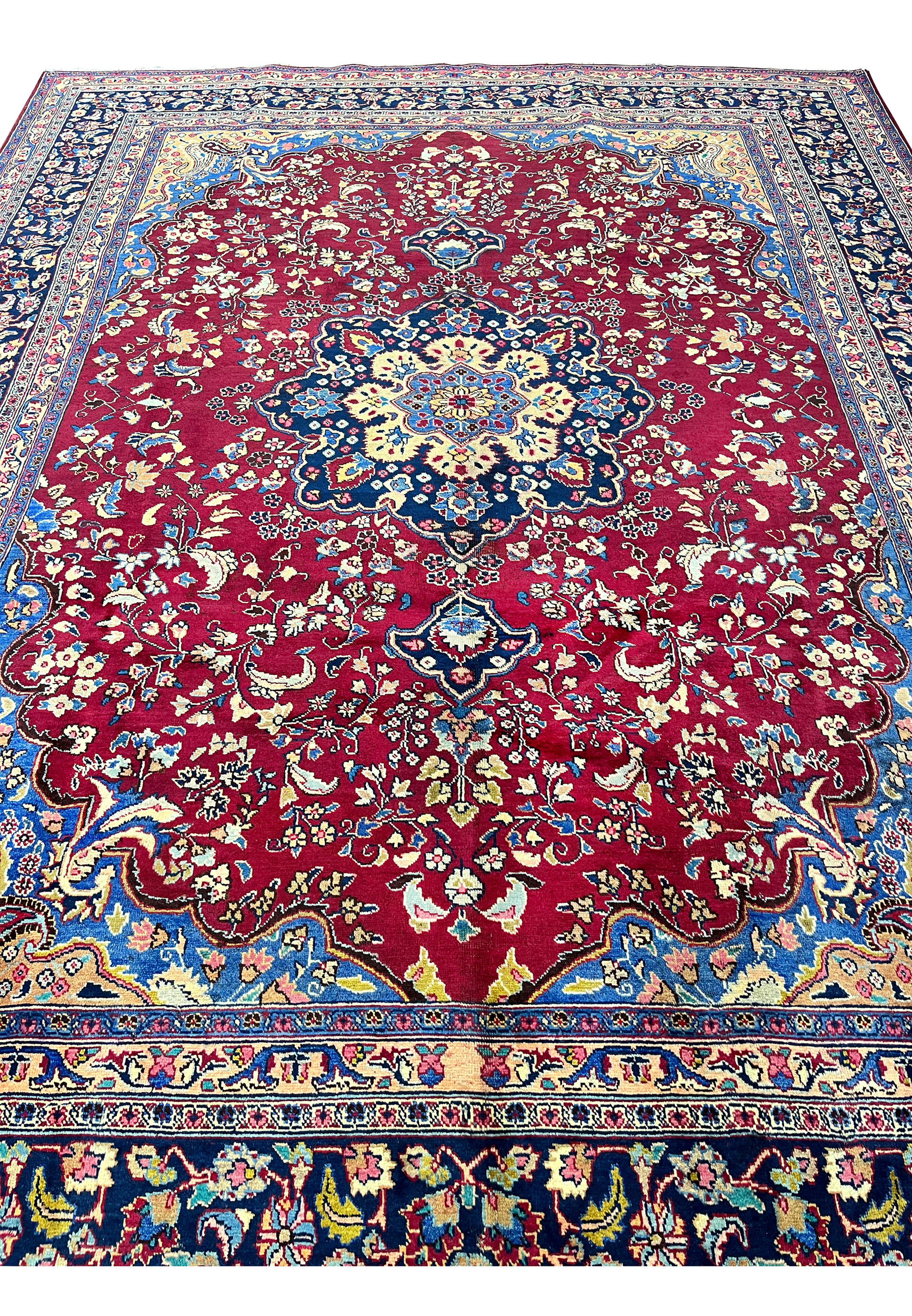 10x13 distressed antique Persian Mashad rug top view red field navy border paisley spandrels