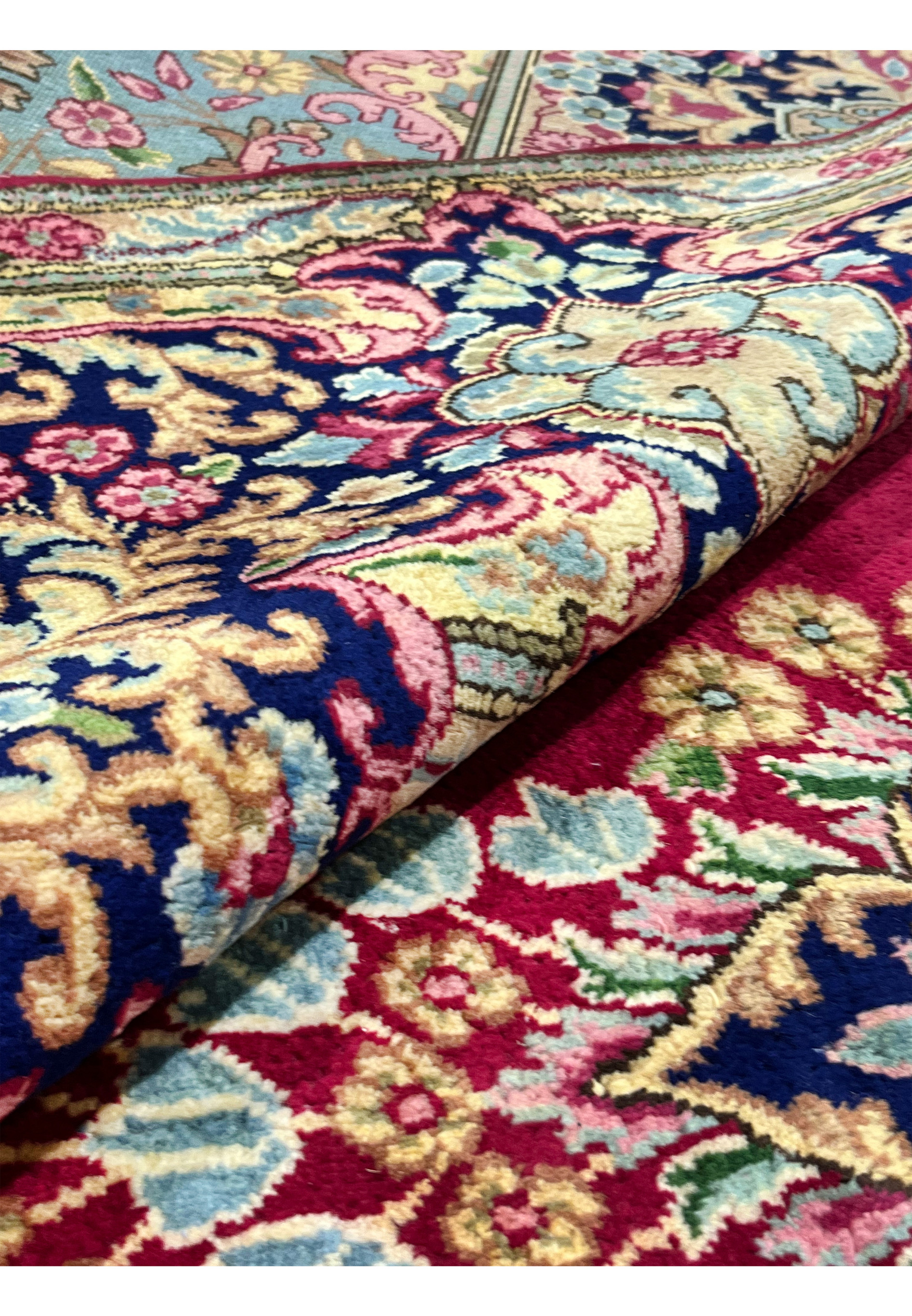 10x14 Persian Kerman rug rolled view wool pile crimson red navy border detail