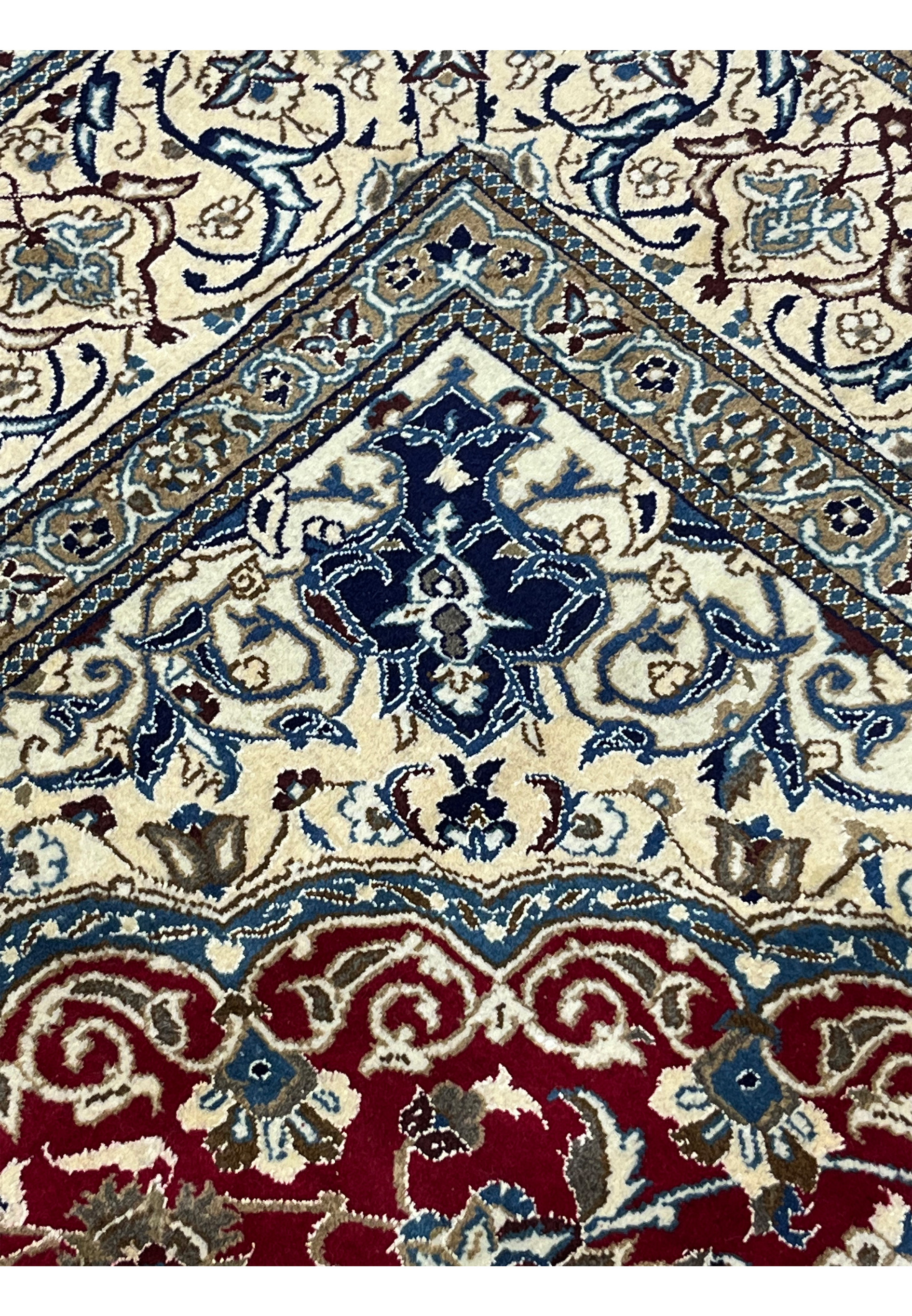 Close-up of red Persian Nain rug showing dense floral pattern with ivory, navy, and light blue detailing