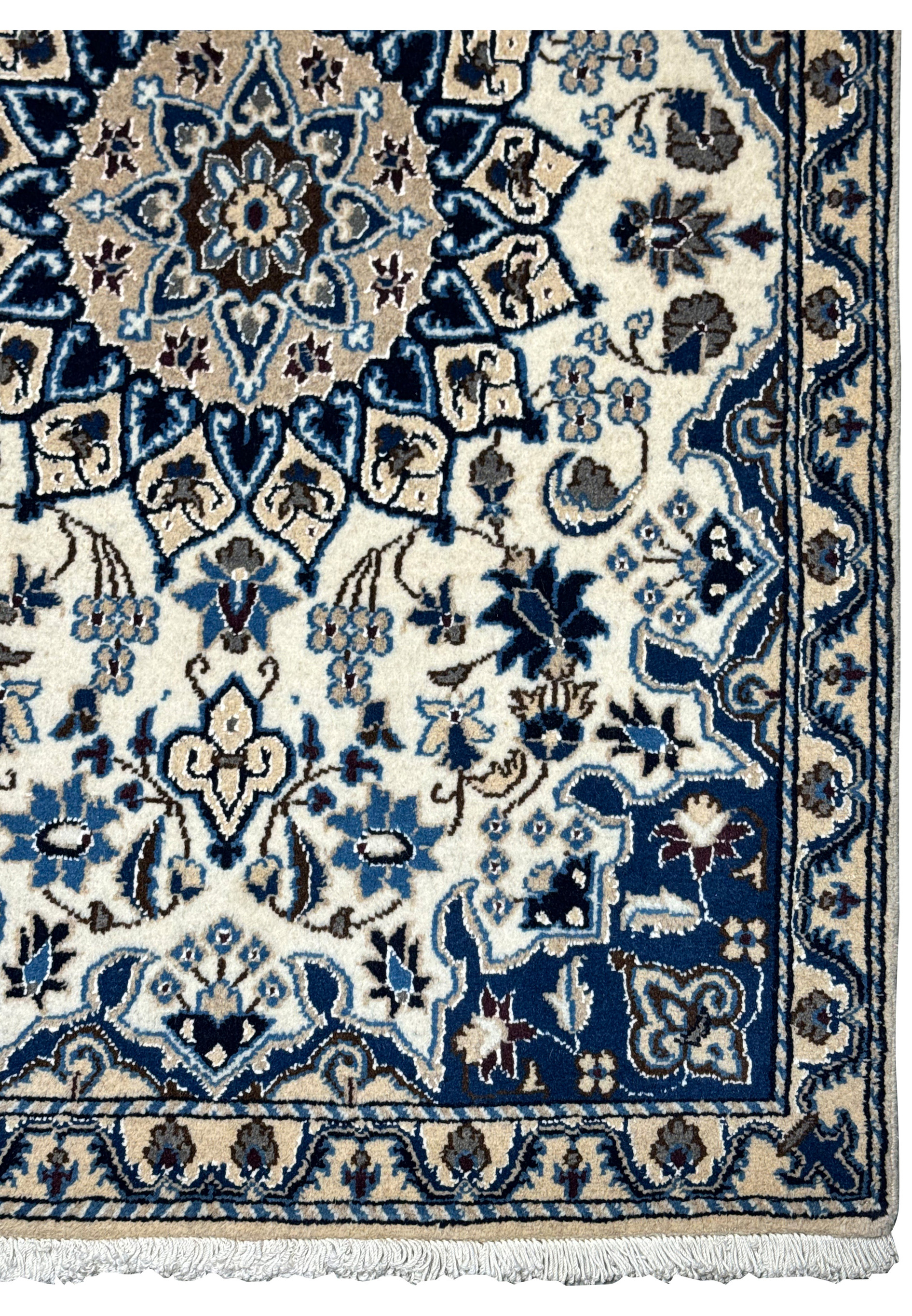 Border view of Persian Nain wool and silk rug with scrolling floral patterns.