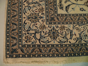 Corner view with border detail and contrast between beige field and blue-accented motifs