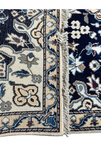 Angled perspective of the Persian Nain rug, accentuating the lush pile and elegant floral patterns