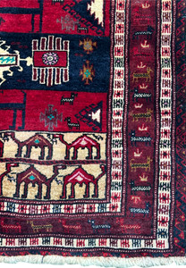 Close-up of the lower end of a Persian Baluch rug, illustrating detailed geometric tribal designs and fringe