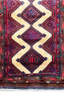 Close-up view of a Persian Hamedan runner rug showcasing diamond motifs and intricate border designs