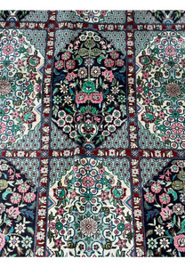 Detail of the central floral medallion on a Persian Qum silk rug, showcasing exquisite craftsmanship