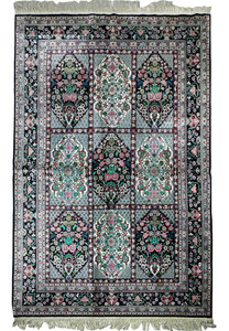 Close-up of the intricate floral and geometric patterns on a Persian Qum silk rug with shimmering silk threads