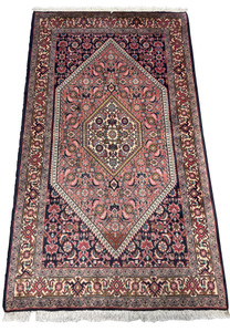 Angled view showcasing the dense weave and rich color variations of the Persian Bijar rug with detailed borders and fringe