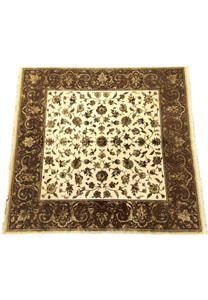 A close-up of the Indian Chobi rug's border, featuring dark brown with intricate vine and floral patterns, alongside a lighter central field of floral designs.
