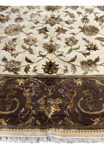 An angled view of the Indian Chobi rug, displaying the rich texture and color variation within the central floral design and border.