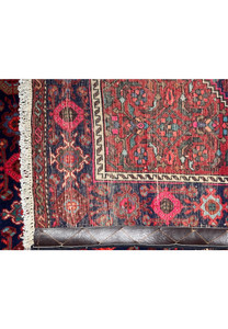 The vibrant color palette and refined details of a Persian Gholtogh rug's weave captured from a low angle for a dynamic visual effect