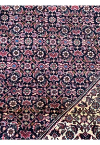 A close-up on the corner detailing of the Persian Bijar rug, illustrating the tight weave and rich color saturation of the wool.