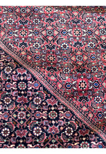 A section of a Persian Bidjar rug displaying the intricacy of its weave and the clarity of its traditional motifs.