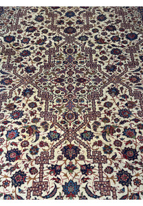 Detailed image of the upper part of the Persian Isfahan rug, showcasing the geometric and floral patterns along with the border.