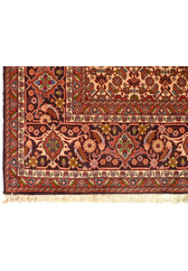 A detailed image of the Bijar rug's border, displaying complex botanical motifs and geometric shapes in a harmonious color palette against a deep red background.