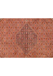 A close-up of the central diamond medallion within the Bijar rug, highlighting the detailed patterns and color variations, with a focus on the intricacy of the weave.