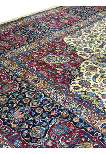 Close-up view of detailed floral motifs and intricate patterns on a Persian Mashad rug, showcasing vibrant colors such as red, blue, ivory, and gold, with meticulous craftsmanship and traditional Persian design elements.