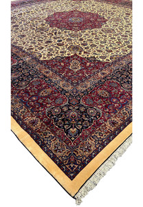 Angled view of a large Persian Mashad rug, highlighting the detailed central medallion and surrounding intricate patterns, with vibrant colors including deep red, blue, and ivory, set within a beautifully patterned border