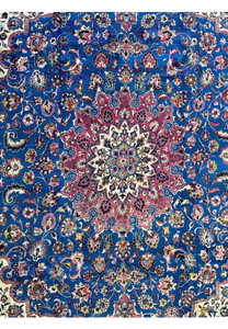 Detailed view of the central field of a Persian Mashad Rug, featuring a complex pattern of floral and vine motifs in navy blue and red