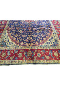 Detailed image of the 10'6 x 15'8 Persian Najafabad Rug, highlighting the intricate border design with floral and arabesque patterns. The vibrant red border contrasts beautifully with the navy blue field and gold and ivory details, adding elegance to any room