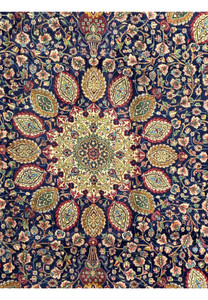 Detailed section of the Persian Tabriz Rug, focusing on the upper central part. The image reveals the precise and elaborate design, with floral and leaf motifs intricately woven in rich hues of red, green, and gold. The craftsmanship is evident in the fine detailing and harmonious color palette, which enhances the overall aesthetic of the rug.