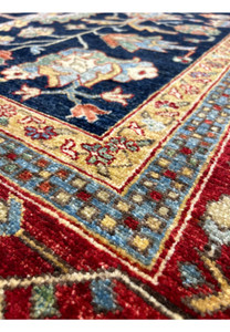 Detailed view of the border of a Ziegler rug, featuring a mix of floral and geometric patterns in red, gold, and light blue.