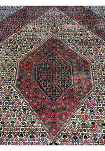 Central medallion view of a 9.8 x 12.2 Persian Bijar rug with layered geometric forms, dark red and navy tones, and a densely knotted symmetrical design.