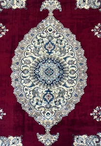 Close-up of the central medallion on the 6'8 x 10'4 Persian Nain 9LAA Wool & Silk Rug, featuring intricate floral designs in navy and light blue.