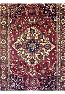 Close-up of the central medallion on the 6'6" x 10' Persian Bakhtiar rug highlighting detailed geometric and floral motifs in red, navy blue, and ivory.