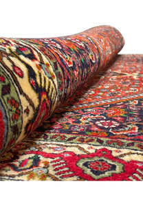 Side view of 3'9" x 5'6" Persian Bijar Rug rolled up, revealing rich color palette and craftsmanship.