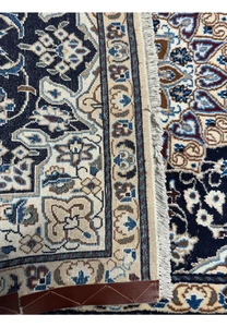 Backside of the 3x5'3 Persian Nain Rug showing the fine weave and density, with a measuring tape to indicate quality.