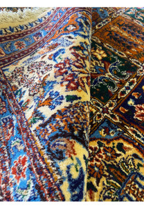 Rolled side view of the Persian Moud Rug showcasing the thickness and texture of the wool.
