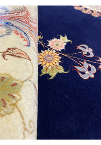 Rolled view of the 10x13 Persian Tabriz Silk rug highlighting the rug's texture and pattern continuity.