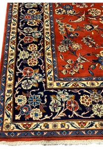 Detailed view of the floral motifs on the 6'6 x 10'2 Persian Sarough Rug with a rich burnt orange background.