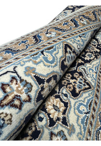 2'11 x 5'1 Persian Nain rug rolled to display the hand-knotted craftsmanship and intricate patterns.