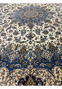 Midfield design of the 16' x 16' Persian Nain rug with navy blue and ivory floral patterns.