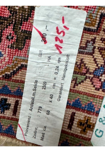 Close-up of the product tag on the 1'3 x 2 Ardebil Persian Wool & Silk Poshti Rug.