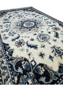 Angled view of the Nain Persian rug showcasing the medallion and floral patterns with intricate borders in a fine wool weave.