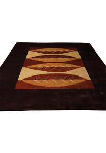 Top view of abstract leaf pattern in earth tones on wool rug