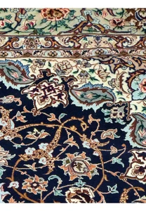Detailed pattern of Isfahan rug featuring scrolling vines, rosettes, and palmettes on navy wool and silk weave