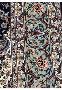 Detailed edge of 5x8 Isfahan rug showing layered floral border and corner vine motifs on a sage green base